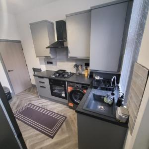 a small kitchen with a sink and a stove at 6 BR Home Free Parking Sleeps 14 Table Tennis City Centre Pool Table in Central Station