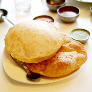 a plate with two pancakes and sauce on a table at Hotel VAAYU Stay IGI Airport in New Delhi +29 photos