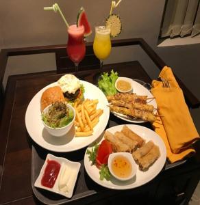 a tray with three plates of food on a table at Hotel VAAYU Stay IGI Airport in New Delhi
