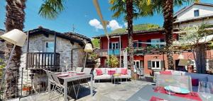 a patio with a table and chairs and a house at Rustico senza punti in Contra