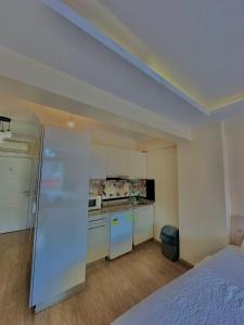a kitchen with white cabinets and a bed in a room at Green Suite in Istanbul