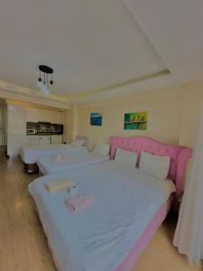 a bedroom with two beds and a pink headboard at Green Suite in Istanbul
