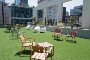 a group of chairs and tables on the roof of a building at Stay Ohana in Seoul