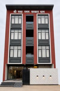 a red brick building with black windows at Shree Radha Raman Sarkar Dham in Vrindāvan +16 photos