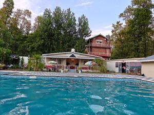 a swimming pool in front of a house at Nature Nest Farms in Chūharpur