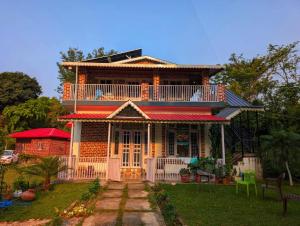 a large house with a balcony on top of it at Nature Nest Farms in Chūharpur
