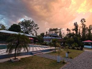 a resort with a swimming pool and a house at Nature Nest Farms in Chūharpur +11 photos