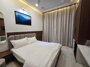 a bedroom with a bed and a television on the wall at Shree Radha Raman Sarkar Dham in Vrindāvan