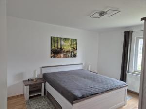 a bedroom with a bed and a painting on the wall at Zum alten Hafen Wesenberg in Wesenberg