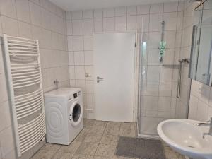 a bathroom with a washing machine and a sink at Zum alten Hafen Wesenberg in Wesenberg +21 photos