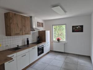 a kitchen with white cabinets and a window at Zum alten Hafen Wesenberg in Wesenberg