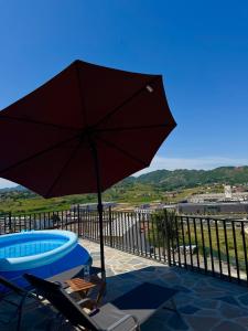 a patio with an umbrella and a table and a pool at Green Hill Villa in Tirana