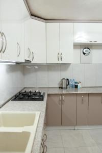 a white kitchen with a stove and a sink at Airport Garden hotel in Pʼarakʼar +19 photos