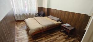 a bedroom with a bed and a chair and a table at Dreamstay lodge in Kohīma