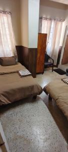 a bedroom with two beds and a mirror and curtains at Dreamstay lodge in Kohīma