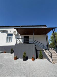 a building with stairs and potted plants in a courtyard at Casa Cedru-piscină cu jacuzzi si sauna in Mileştii Mici