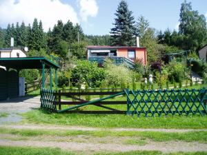 a green fence in the grass with a house in the background at bungalow am schlossäcker in Kurort Steinbach-Hallenberg