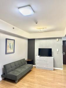 a living room with a couch and a flat screen tv at trendy & Reliable Condo unit in Davao City