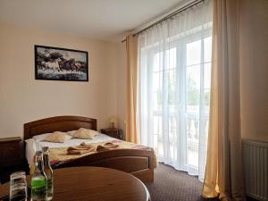 a bedroom with a bed and a large window at Dwór Dziekanów in Zielonki