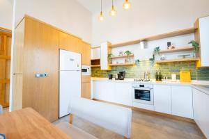 a kitchen with white cabinets and a table and a refrigerator at Villa Palma 2 in Beyobası