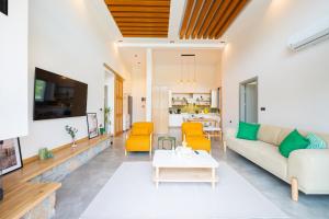 a living room with yellow chairs and a table at Villa Palma 2 in Beyobası