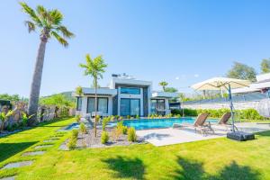 a house with a swimming pool and a palm tree at Villa Palma 2 in Beyobası