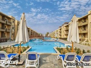 a pool at a resort with umbrellas and chairs at Halaشاليه in Ras Sedr