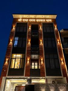 a brick building with a lit up sign on it at Shree Radha Raman Sarkar Dham in Vrindāvan