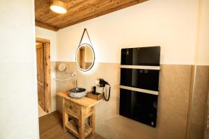 a bathroom with a sink and a mirror on the wall at Frauenalmresort - Chalets in Sankt Lorenzen ob Murau +204 photos