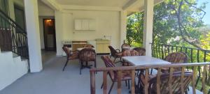 a porch with chairs and a table and a kitchen at Apartmani Vučević in Sutomore