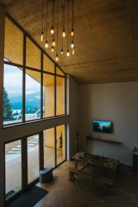 a living room with a table and large windows at Lordis Cabin Tihuța in Piatra Fantanele