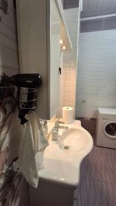 a bathroom with a sink and a washing machine at See4YOU in Odesa +26 photos