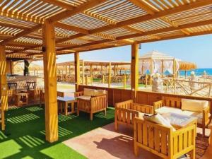 a pavilion with tables and chairs and the ocean at Halaشاليه in Ras Sedr