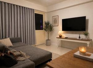 a living room with a couch and a flat screen tv at บ้านเคียงคลื่น in Cha Am