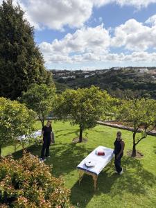 two people standing around a table in a field at Alto Paraíso Boutique Hotel in Reguengo Grande