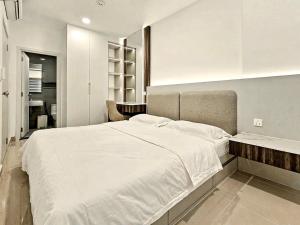 a bedroom with a large white bed and a desk at Modera Suites at Parkland Condo TK in Phnom Penh +41 photos