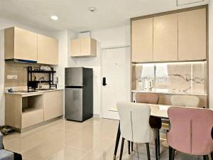 a kitchen with a table and chairs and a refrigerator at Modera Suites at Parkland Condo TK in Phnom Penh