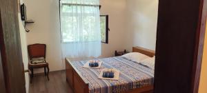 a bedroom with a bed with two plates of food on it at Apartmani Vučević in Sutomore