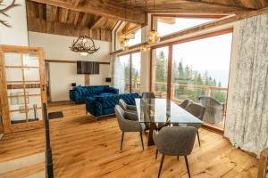 a living room with a glass table and chairs at Frauenalmresort - Chalets in Sankt Lorenzen ob Murau