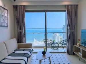 a living room with a couch and a large window at Căn hộ The Song Du lịch biển Tháp Tam Thắng INFINITY POOL FREE IN SIDE THE SEA in Vung Tau +176 photos
