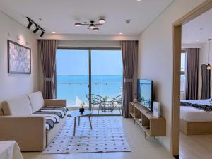 a living room with a couch and a bed and a television at Căn hộ The Song Du lịch biển Tháp Tam Thắng INFINITY POOL FREE IN SIDE THE SEA in Vung Tau