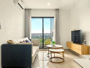 a living room with a couch and a tv at Modera Suites at Parkland Condo TK in Phnom Penh