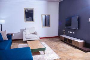 a living room with a couch and a tv at Torriam Apartments in Chongwe
