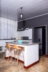 a kitchen with a counter and some chairs in it at Torriam Apartments in Chongwe