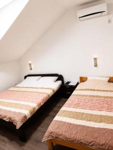 two beds sitting next to each other in a room at Vila Radovanje in Cerovac