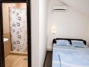a small bedroom with a bed and a shower at Vila Radovanje in Cerovac