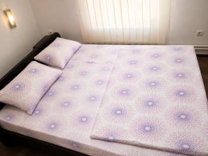 a bed with purple polka dot sheets and pillows at Vila Radovanje in Cerovac