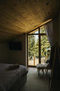 a bedroom with a bed and a large window at Lordis Cabin Tihuța in Piatra Fantanele