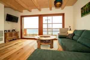 a living room with a green couch and a table at Frauenalmresort - Chalets in Sankt Lorenzen ob Murau