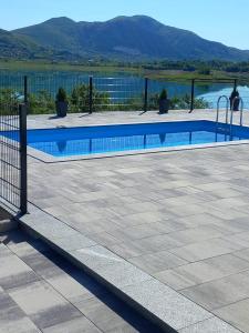 a swimming pool with a fence next to a lake at Kuća za odmor Ana in Prozor